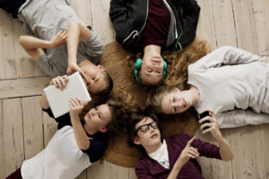 Teenagers lying on floor with Ipad and mobile